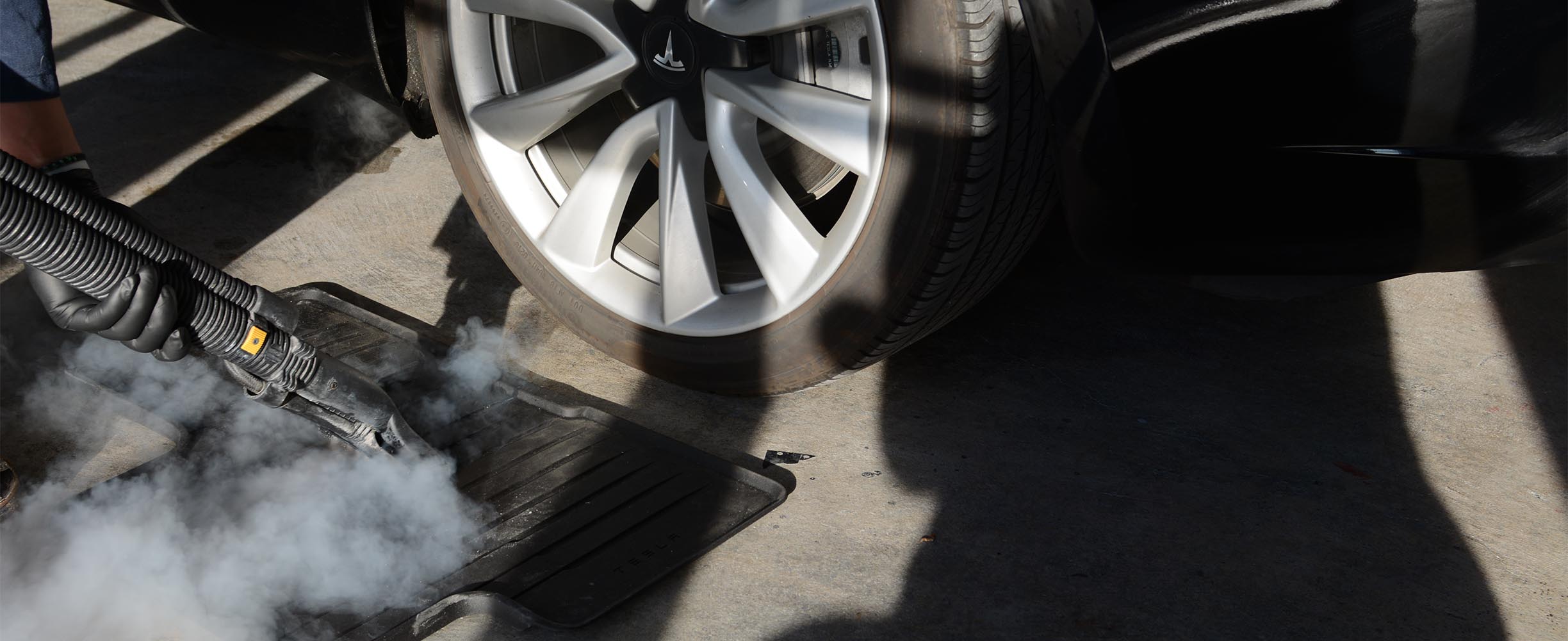 Steam cleaning a floor mat, and interior auto detailing service.